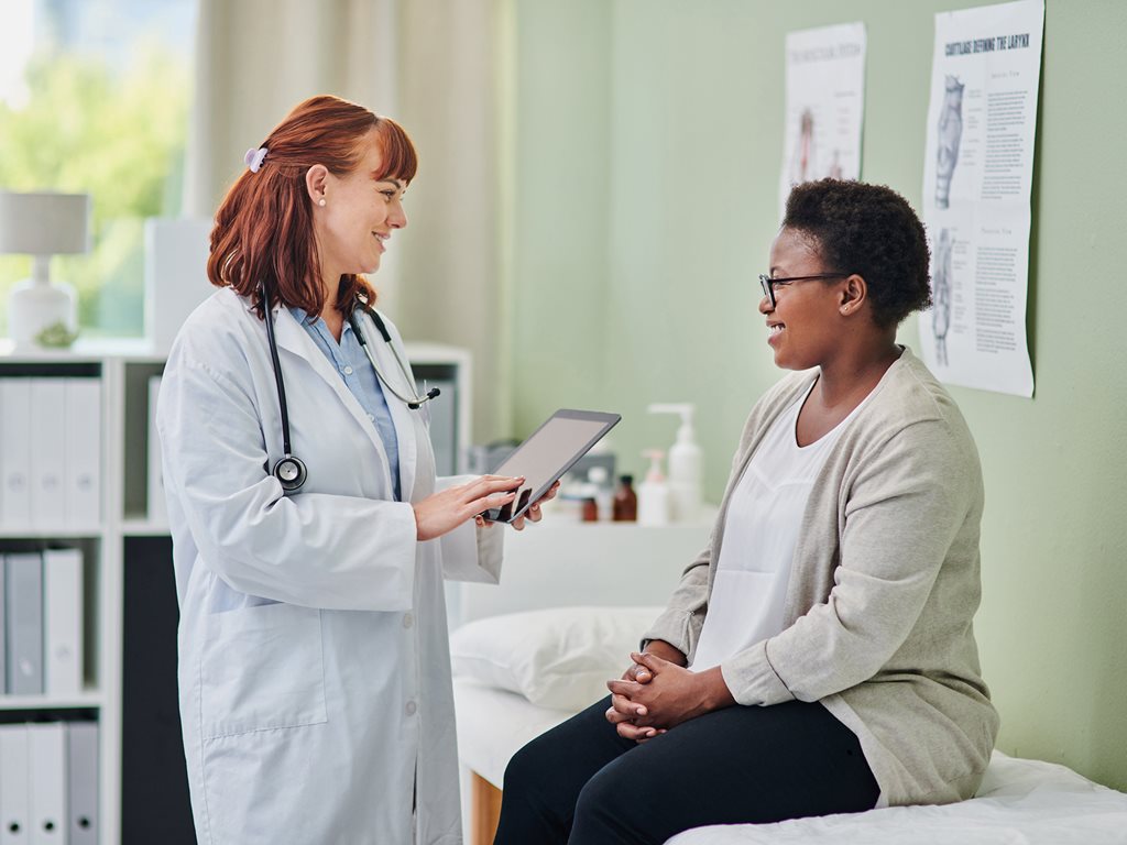 Female physician using a digital tablet during a consultation with a female patient